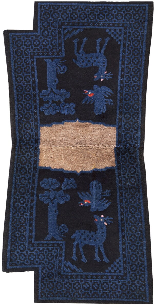 Black runner rug with dark blue animal and tree motifs, geometric borders, and a tan horizontal stripe.