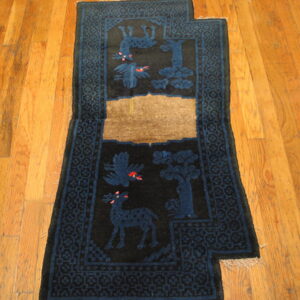 Dark blue runner featuring stylized animal motifs and geometric borders sits on light hardwood flooring.