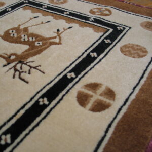 Cream and brown high-pile rug with a central deer design bordered by black and white lines.