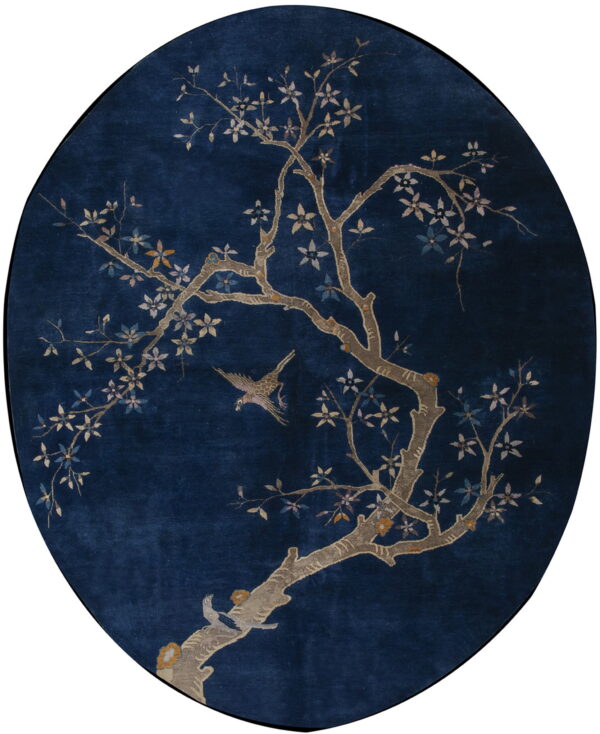 Dark blue oval rug featuring a detailed tree pattern with light-colored blossoms and two birds.