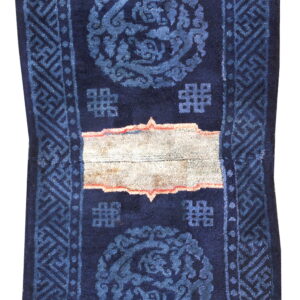 Dark blue rug runner with fading blue patterns and a distinct light tan horizontal band in the middle.