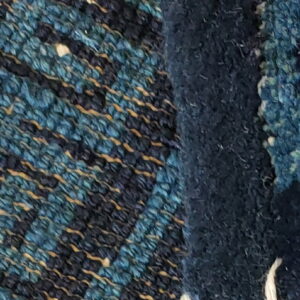 Blue rug texture detail showing dense high pile next to a woven pattern with gold accents.