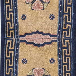 Tan runner rug with dark blue trim, detailed pink florals, and a light blue meander pattern border.