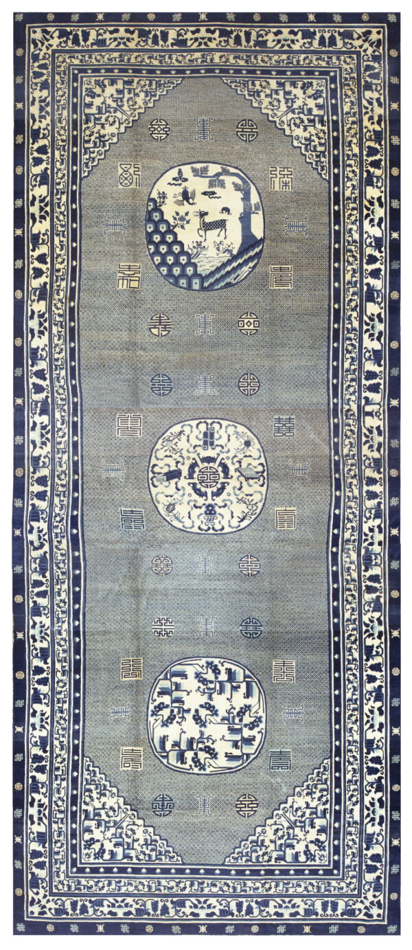 A long slate blue rug detailed with high contrast navy borders and three large central pictorial medallions.