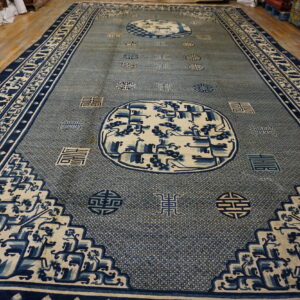 Large blue and cream rectangular rug displaying dense geometric patterns, medallions, and detailed borders on a wood floor.