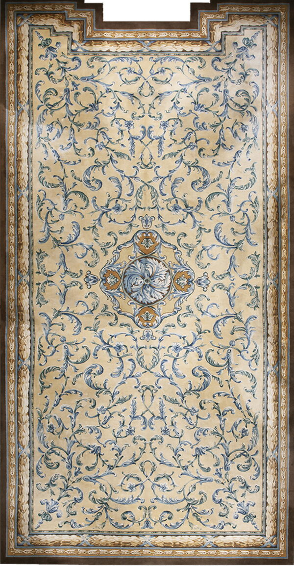 A rectangular beige rug featuring an elaborate blue foliate pattern and a wide brown outer border.
