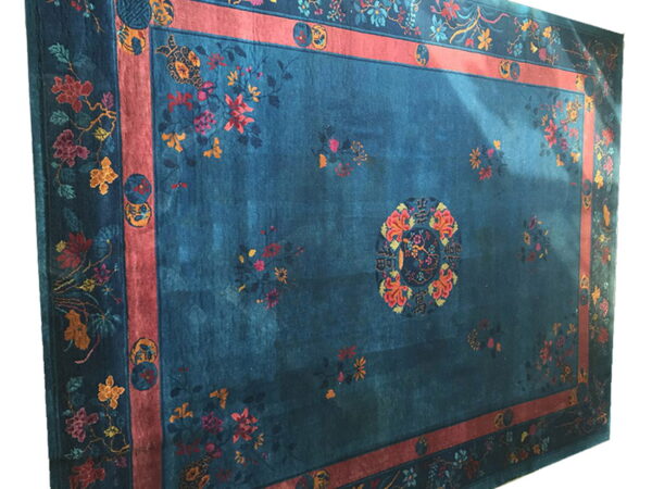 Teal rug featuring a multicolored floral pattern, a central medallion, and a broad rust-colored inner border.