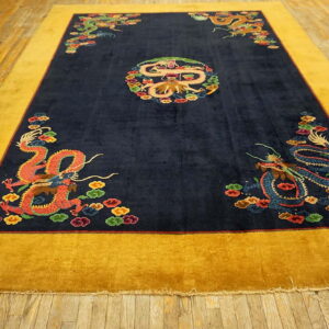 Navy blue rug with a gold border and colorful dragon patterns rests on rustic wood planks.