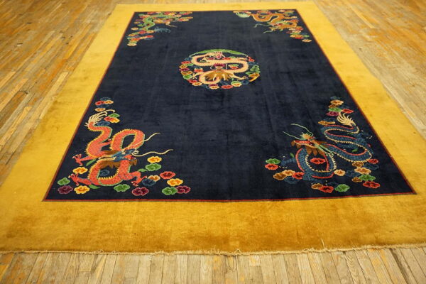 Navy blue rug with a gold border and colorful dragon patterns rests on rustic wood planks.
