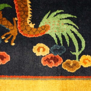 Close-up of a navy rug featuring a multicolored dragon pattern and bright yellow border detail.