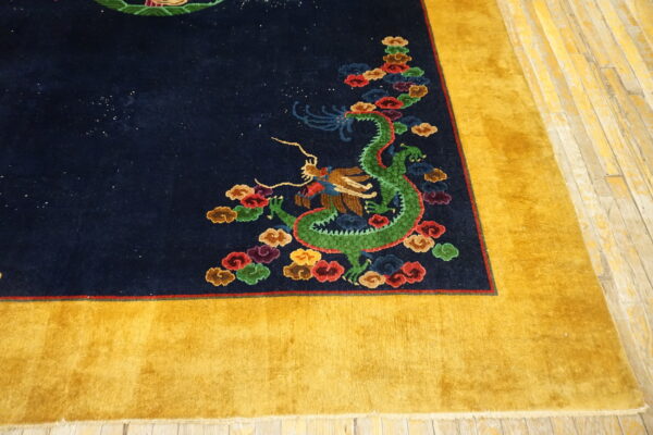 Plush navy rug featuring a colorful green dragon pattern and wide golden yellow outer border on wood flooring.