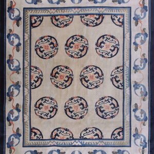 Light beige rug featuring navy circular dragon motifs and a multi-layered border with blue crane designs.