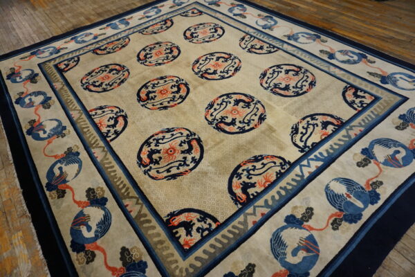 Beige rug with navy and coral medallions and a wide border depicting blue cranes on wood planks.