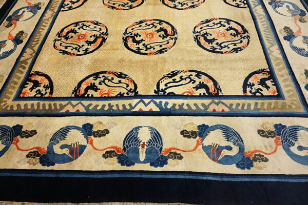 Beige rug with navy and orange stylized dragon medallions and a border featuring blue and white birds.