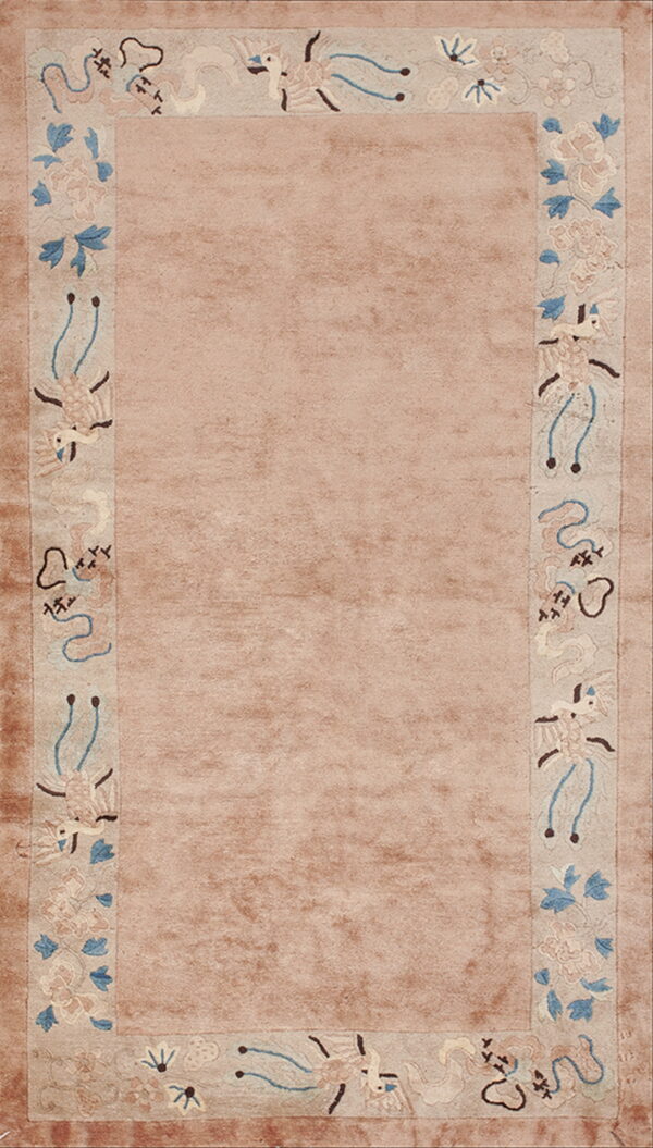 Dusty rose rug with a wide, light decorative border showing stylized birds and pale blue foliage.