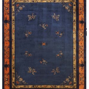 Navy blue rug featuring scattered small floral motifs and a complex, wide orange and tan border.