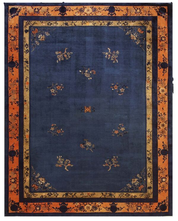 Navy blue rug featuring scattered small floral motifs and a complex, wide orange and tan border.