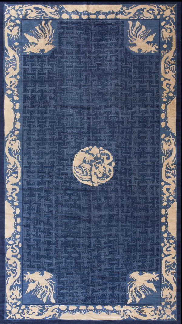 Deep blue rug with beige mythical creatures in the border and a geometric fretwork pattern field.