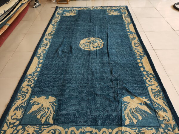 Plush teal rug with detailed tan mythological creatures and a dark geometric field pattern on tile flooring.