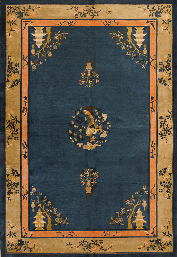 A navy blue rug with gold, pink, and tan borders featuring pagoda and bird motifs on wood floor.