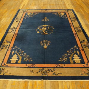 Navy and tan rug displaying Asian-style pagodas and birds, set on shiny wood flooring.