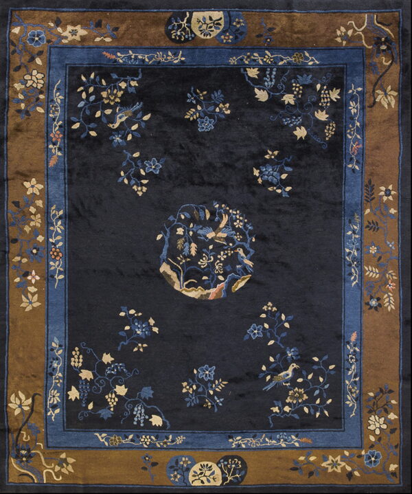 Dark navy rug with elaborate blue and gold floral and bird patterns, framed by a wide brown border.