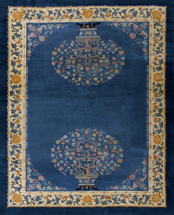 Navy rug with two central flowering vase designs and an ornate tan and blue floral border.
