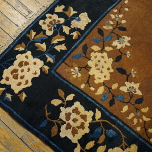 High-pile rug with navy and rust fields featuring cream and blue floral motifs on yellow wood floors.