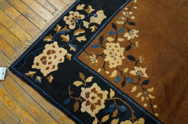 High-pile rug with navy and rust fields featuring cream and blue floral motifs on yellow wood floors.