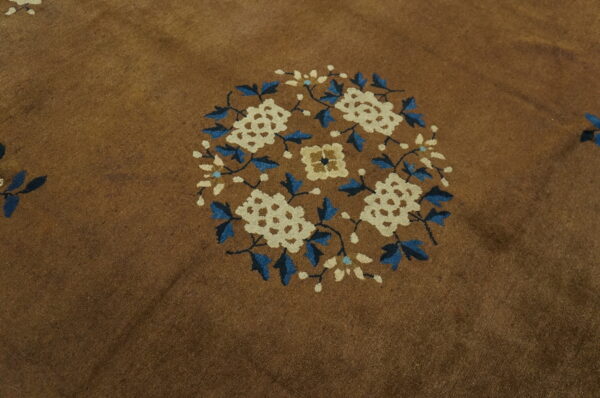 Brown rug detail showing a round floral motif in blue and cream colors.