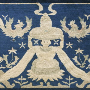 Textured navy blue rug displaying a beige pattern of dragons, flying birds, and a central crowned figure.