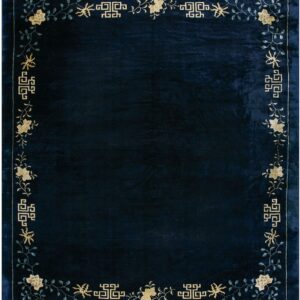 Deep navy rug with a beige floral, vine, and geometric patterned border.