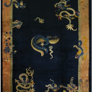 A dark navy plush rug features gold and blue dragons and phoenixes within a wide copper border.