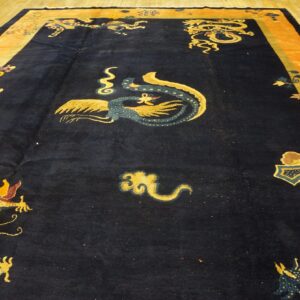 Plush, navy rug with gold dragon motifs and wide orange borders rests on light wood floorboards.