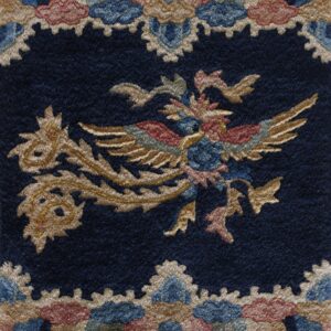 Plush navy rug detail featuring a gold, red, and blue mythical bird figure surrounded by scalloped motifs.