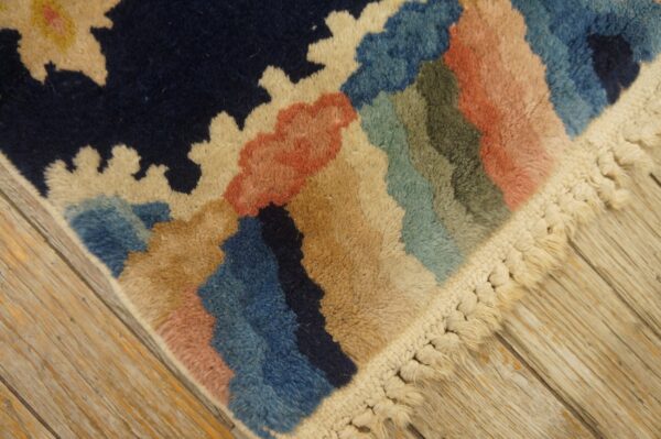 Colorful high-pile rug with abstract patterns and thick knotted fringe resting on light wood flooring.