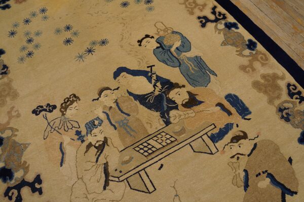 Beige rug with a detailed scene of figures in blue and tan, framed by a dark blue border.