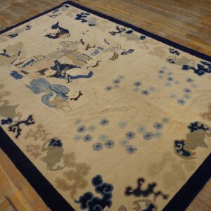 Scenic pictorial rug in tan, navy, and light blue with a dark border on distressed wood plank flooring.