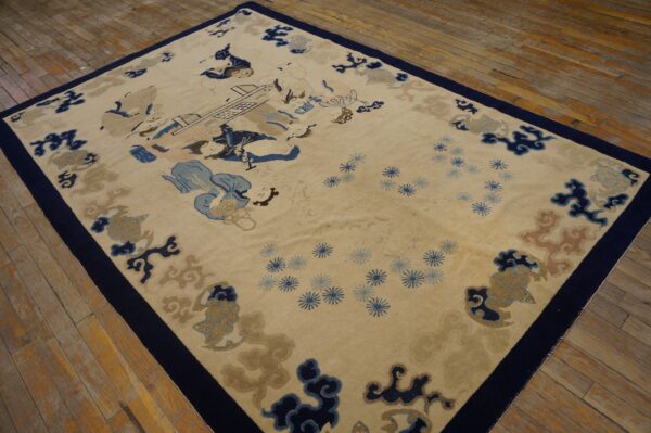 Scenic pictorial rug in tan, navy, and light blue with a dark border on distressed wood plank flooring.