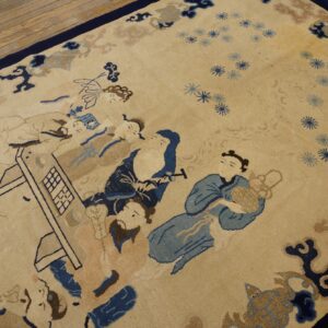 Beige rug with navy, blue, and tan figural pattern resting on light hardwood floors.