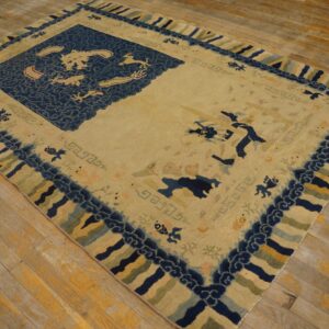 Cream and indigo rug with mythological animal motifs and striped borders rests on weathered wood planks.