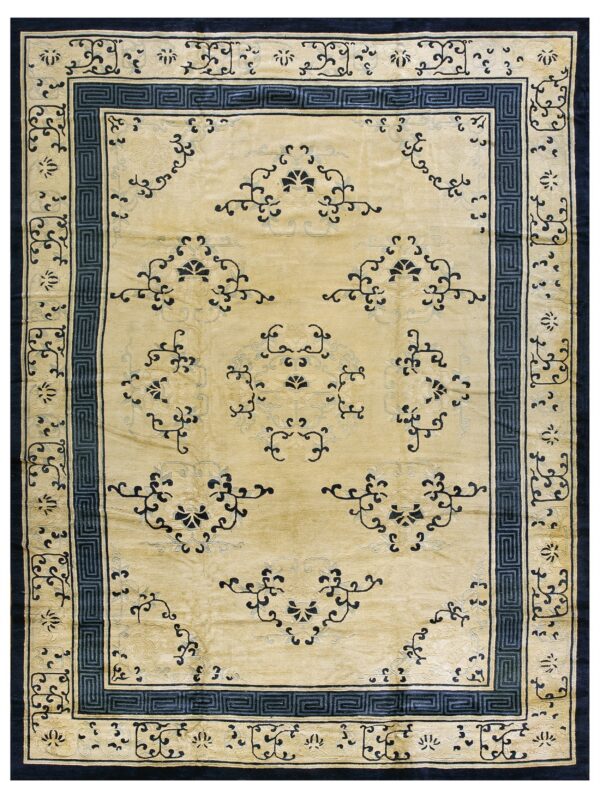 Light gold rug with navy blue geometric greek key borders and scattered floral designs.