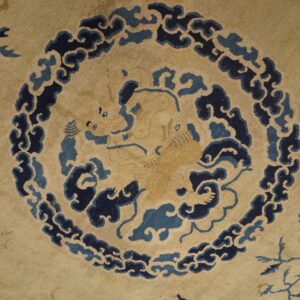 A tan rug detail shows a central stylized creature bordered by dark and medium blue cloud patterns.