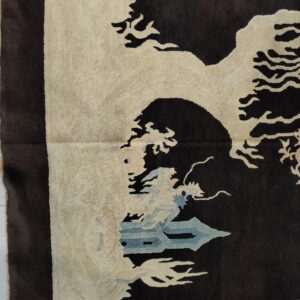 Brown rug corner showing a thick pile cream landscape pattern with light blue elements.