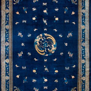 Navy blue rug featuring a golden phoenix medallion, scattered flowers, and geometric borders.