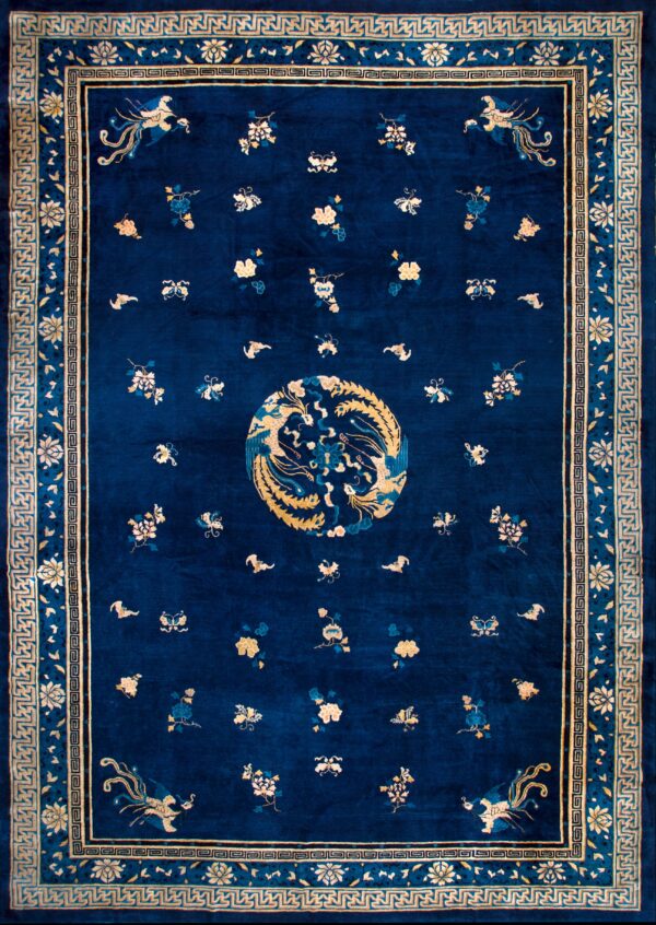 Navy blue rug featuring a golden phoenix medallion, scattered flowers, and geometric borders.