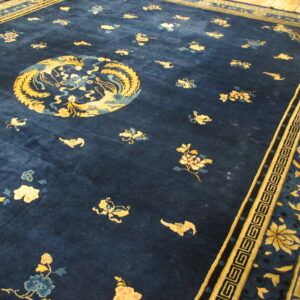 Deep blue rug featuring a central gold medallion, scattered floral motifs, and complex geometric borders.