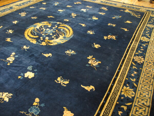 Deep blue rug featuring a central gold medallion, scattered floral motifs, and complex geometric borders.