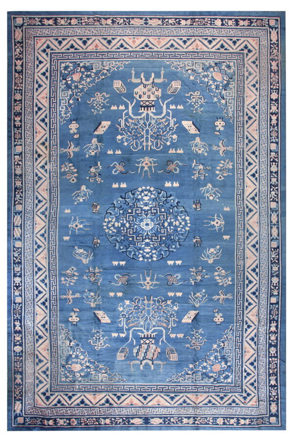 Deep blue rug with intricate multi-layered borders and stylized medallions in light blue and blush tones.