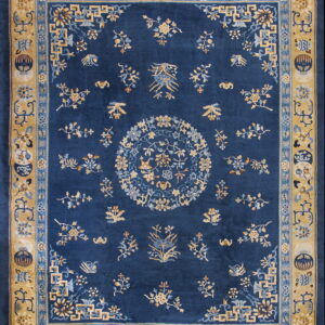 Intricate deep blue rug with a central medallion and scattered gold and light blue botanical designs on a gold border.
